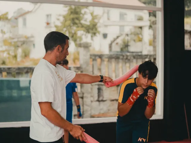 Entrenador trabajando manoplas con un joven boxeador