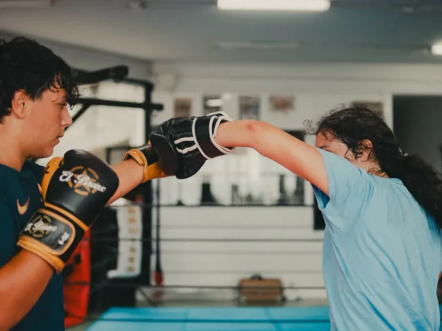 Dos jóvenes practicando golpes durante la clase